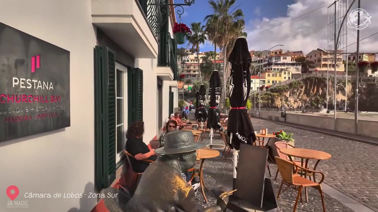 Barcos de pesca de vivos colores alineados en la playa de piedra negra de Câmara de Lobos, con casas encaladas en el acantilado que hay detrás